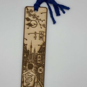 Découvrez ce marque-page en bois gravé au laser inspiré du Japon. Paysage japonais, fleurs de cerisier, dragon et pompon bleu. Fabrication artisanale française.