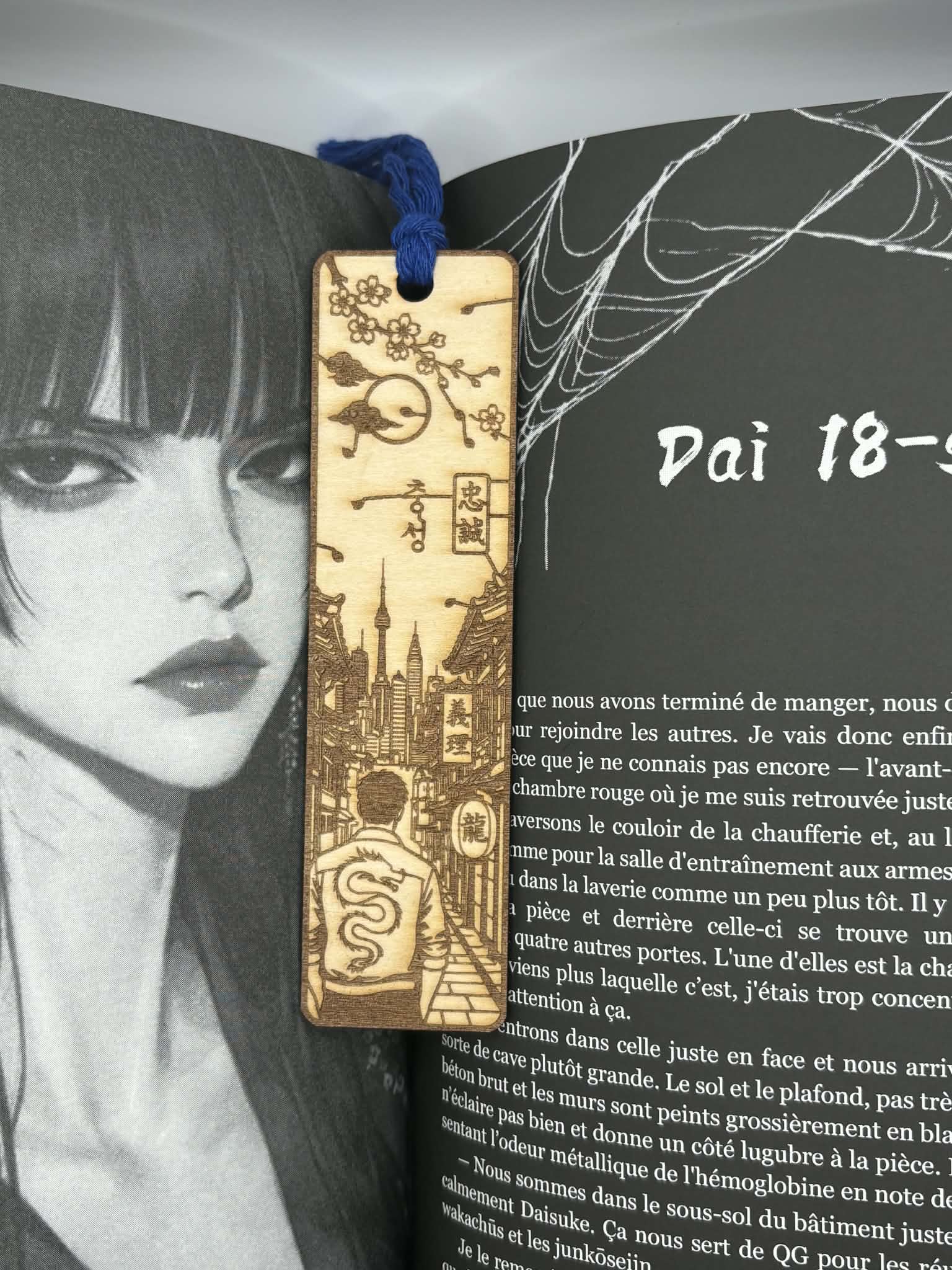 Découvrez ce marque-page en bois gravé au laser inspiré du Japon. Paysage japonais, fleurs de cerisier, dragon et pompon bleu. Fabrication artisanale française.