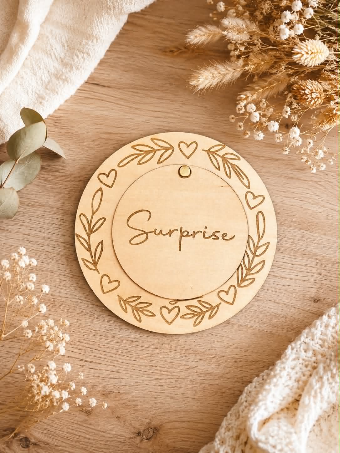 Plaque en bois personnalisée avec disque pivotant "Surprise" révélant une demande de marraine gravée, décorée de feuilles et de cœurs.