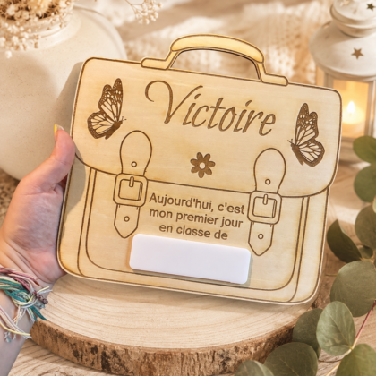Immortalisez le premier jour d'école avec ce tableau cartable personnalisé en bois. Réutilisable chaque année grâce à sa plaque effaçable. Fabrication artisanale.